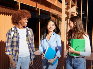 Young man and young women students talking and carrying books