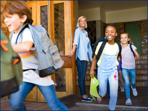 woman holding door open while children are running through