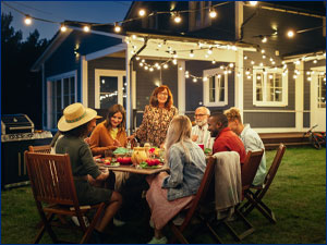 Group of people sitting at a table in a backyard