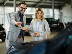 Car saleman shows woman a new car