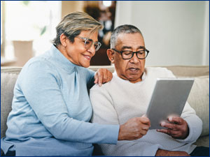 Older woman and man look at tablet together