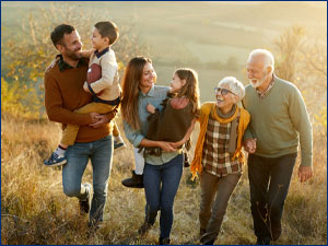 Multigenerational family hiking through field