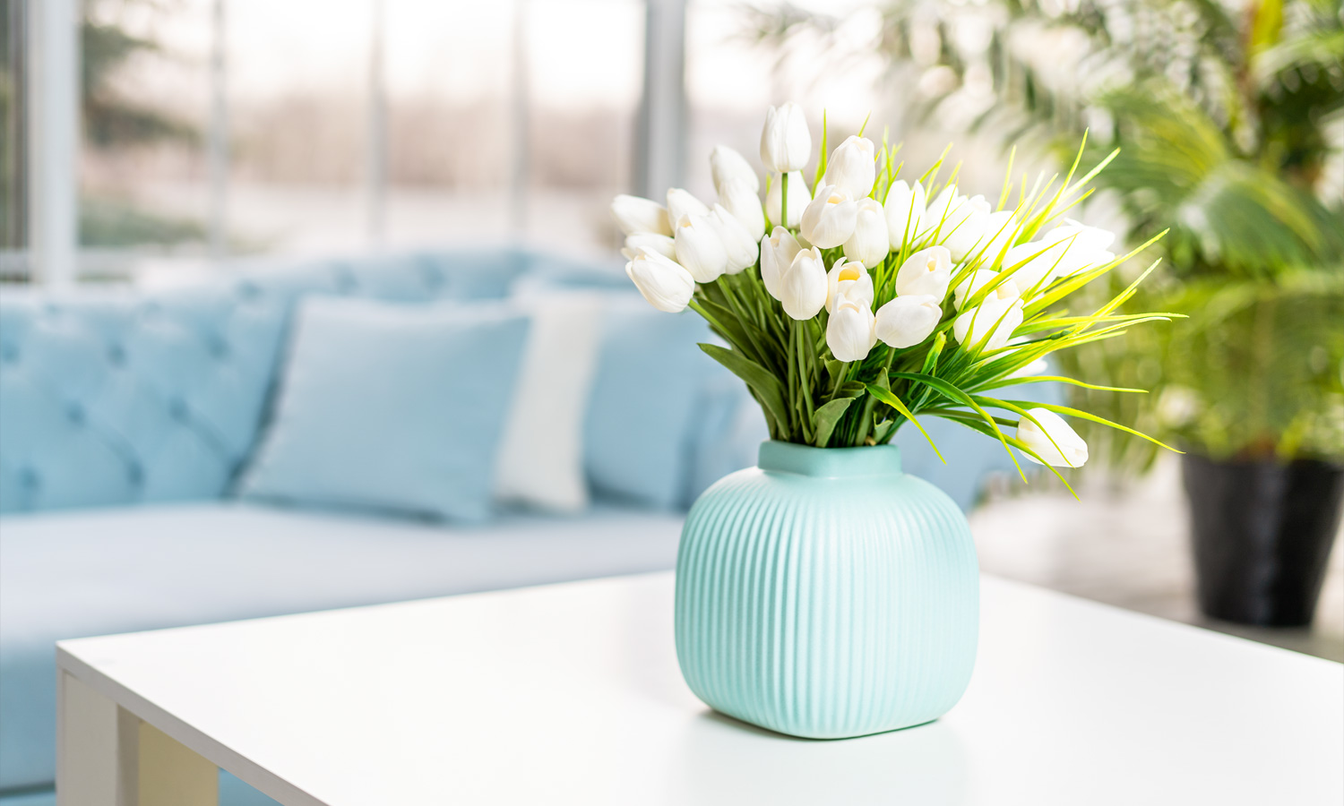 Vase of tulips on table in nicely decorated room