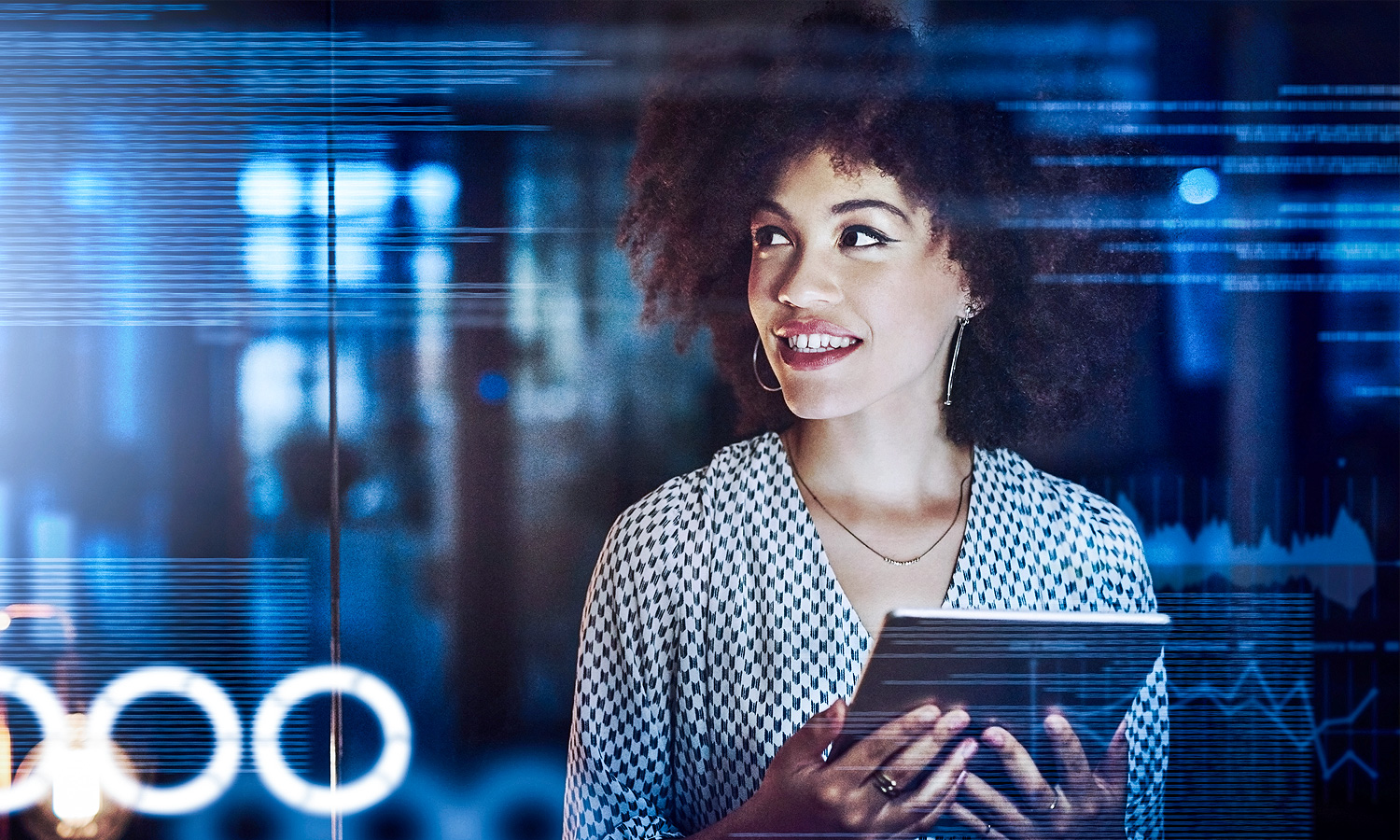 Woman holding a tablet with charts in the background.