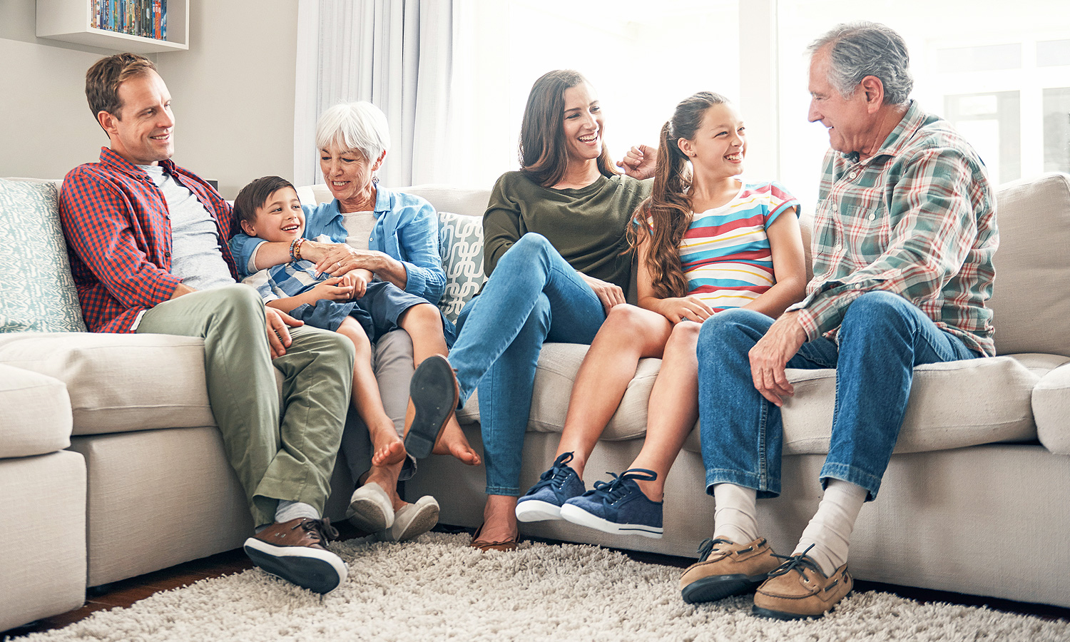 Multi-generational family sits on couch together