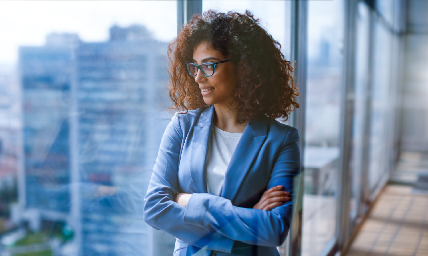 Woman with arms crossed looking out the window