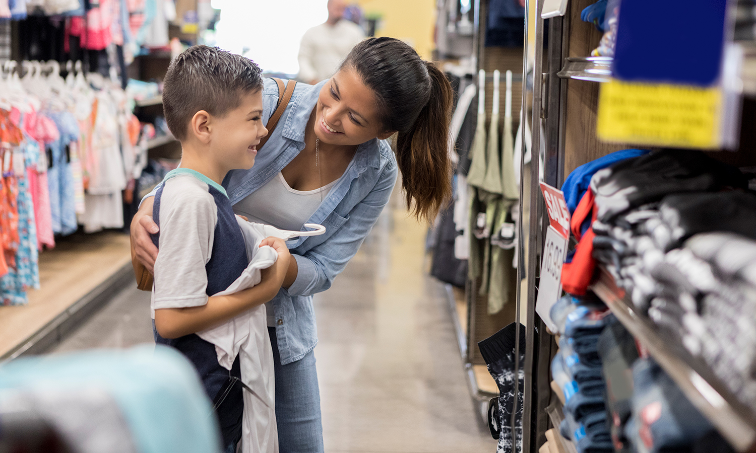 Mother and young son shopping for school clothes