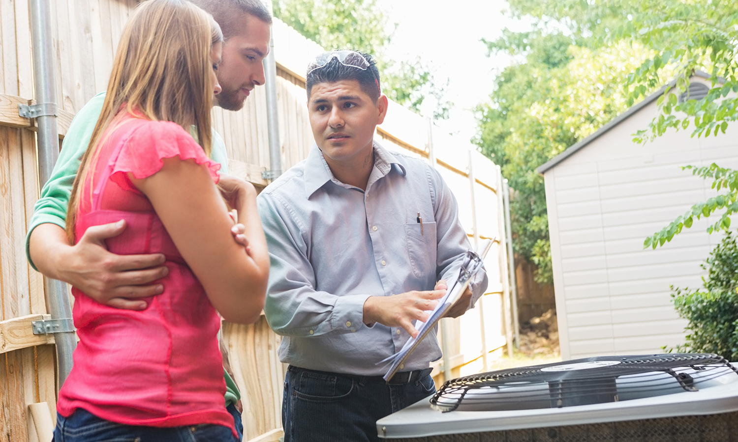 Air conditioning repair man showing repair to man and woman