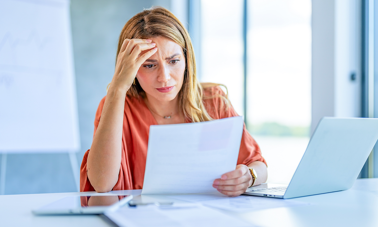 woman looking overwhelmed at paperwork