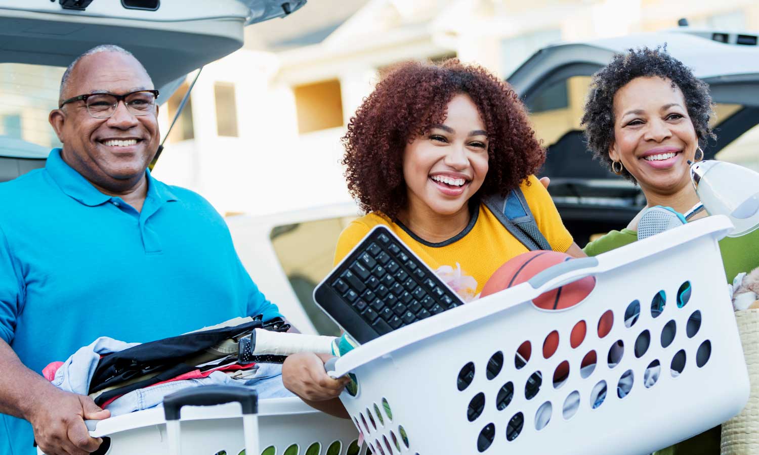 man, teen and woman carrying baskets full of clothing, electronic and sports items