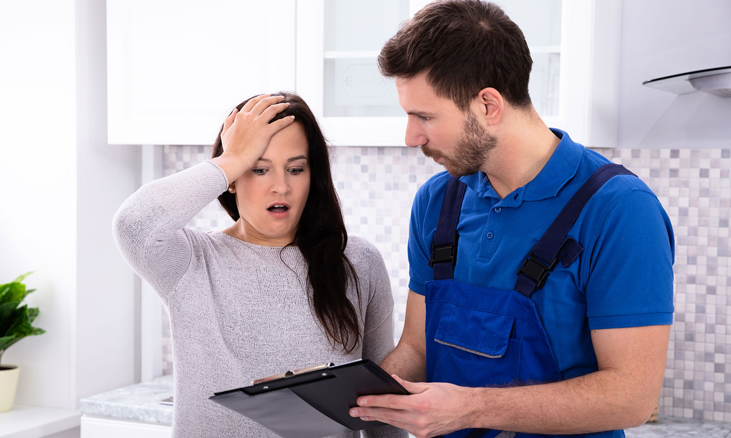 man holding clipboard and woman looking at clipboard in disbelief