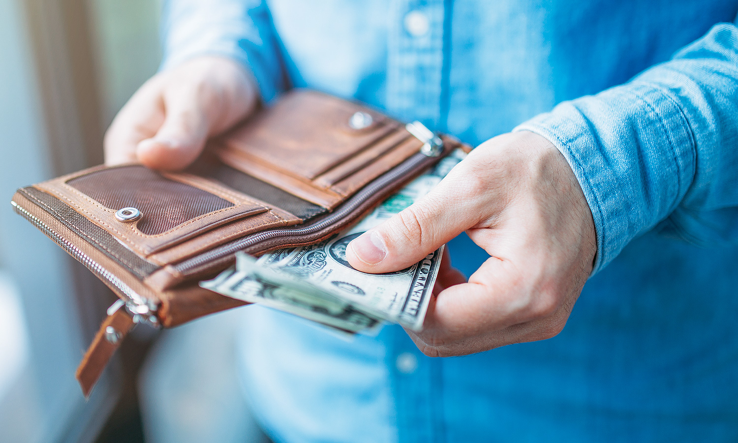 person pulling cash out of wallet