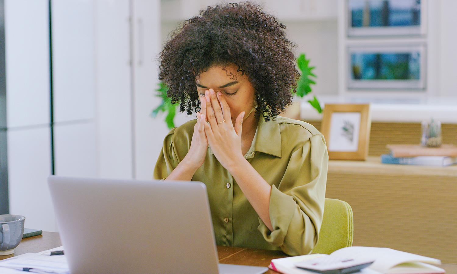 woman looks stressed sitting in front of laptop