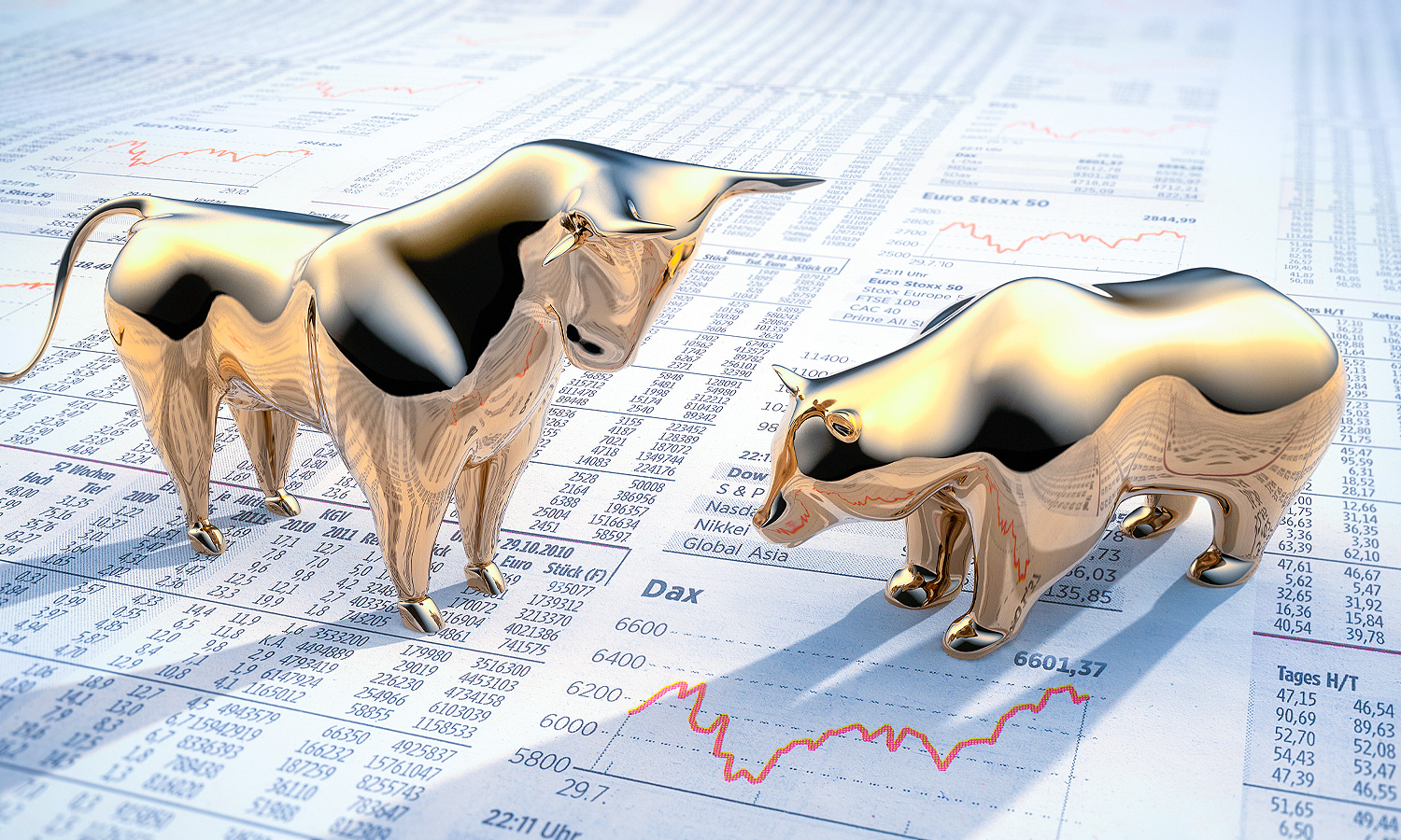 gold bear and bull paper weights on top of papers with charts