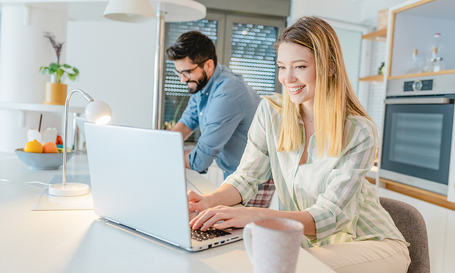 Woman on laptop and man in background