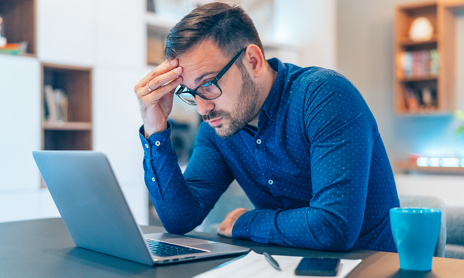 man looking at laptop in distress