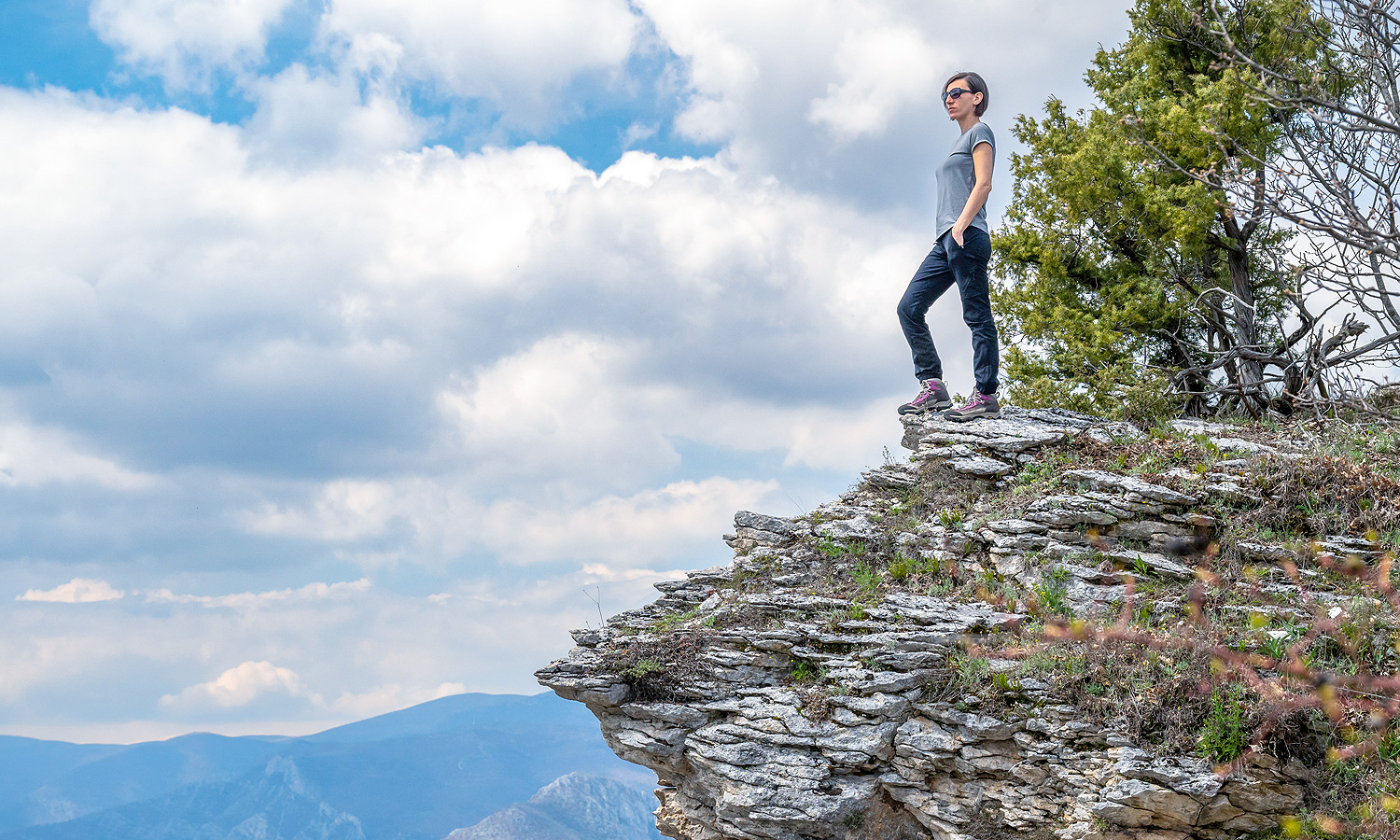 person standing on top of a cliff looking out onto the horizon