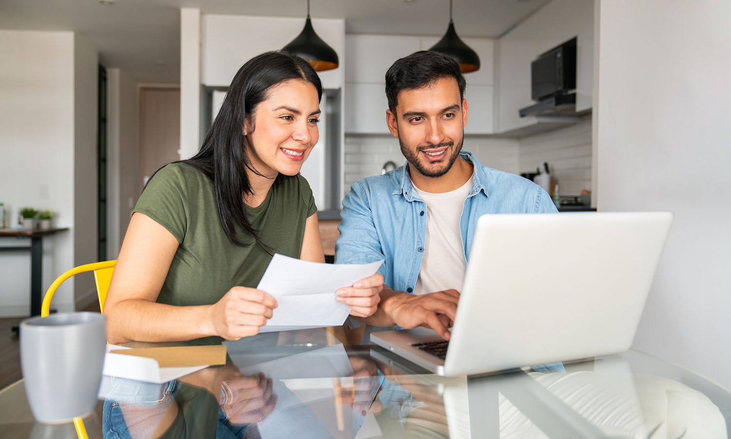 man and woman sitting at table looking at laptop