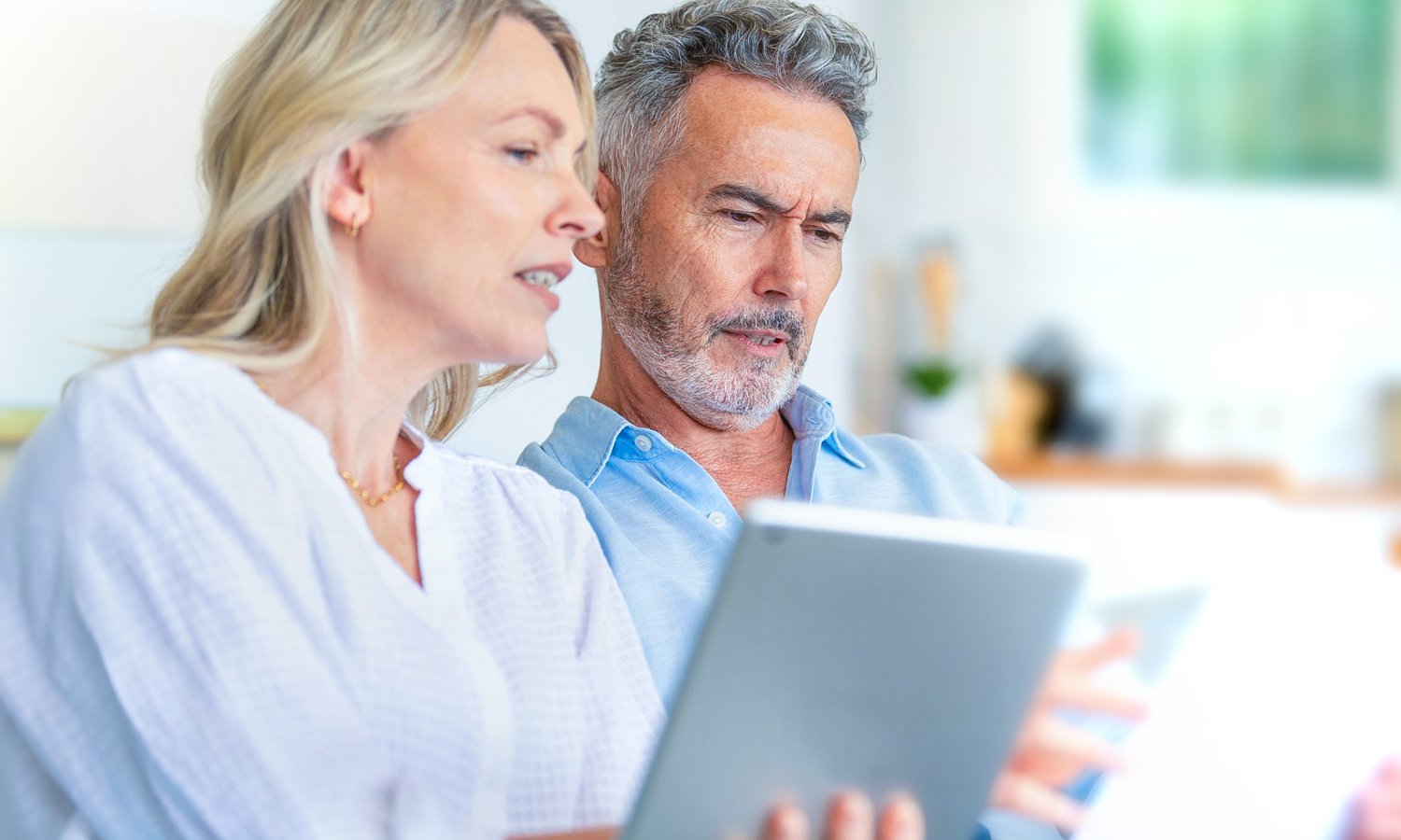 woman and man looking at a tablet.