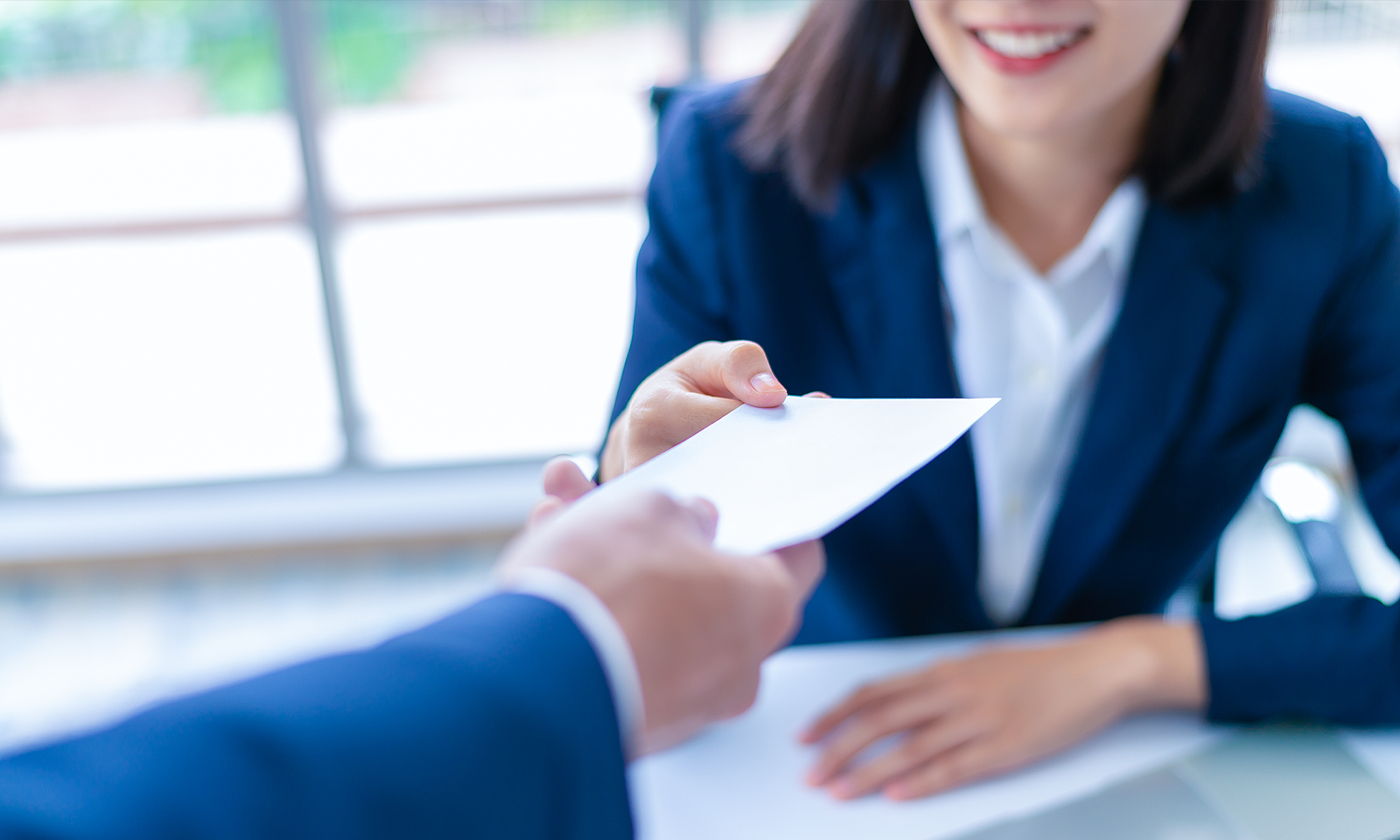 Person handing a piece of paper to a woman.